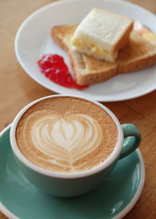 hot latte coffee with bread and strawberry jamの写真素材