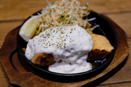 salmon grilled on hot plate with salad and lemonの写真素材