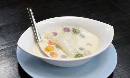 Popular and famous thailand dessert, Thai dumplings in coconut cream and egg on wood tableの写真素材