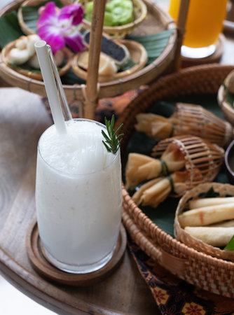Glass of tasty coconut flavored with thai dessert background