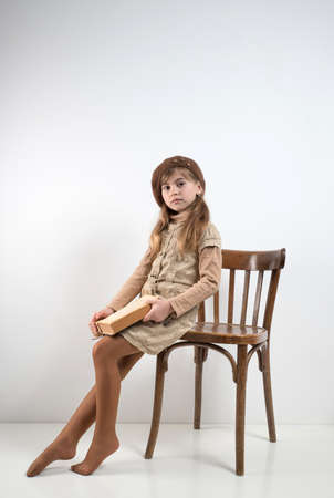 Lutsk. Ukraine. February 1, 2020; Girl reads a book sitting on an old chairのeditorial素材