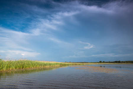 Thunderclouds over the lake. Reflection of the sky in the water.の写真素材