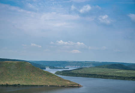 Beautiful landscape of a big river with mountains under a blue sky.の写真素材