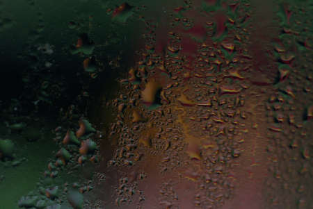water drops on wet window glass with city lights