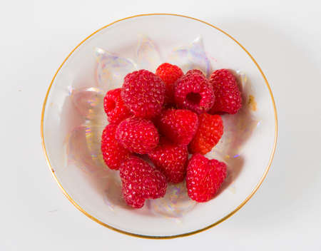 Raspberries on a plate on a white background.の写真素材