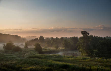 Morning fog over the river floodplain at dawn.の写真素材