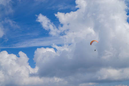 Paragliding in the cloudy blue sky.の写真素材