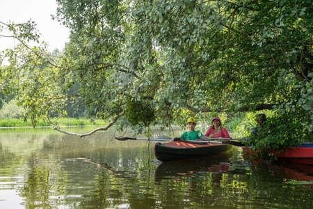 River Goryn. Ukraine. June 10, 2020; A group of tourists swim on the river in multi-colored kayaks.のeditorial素材