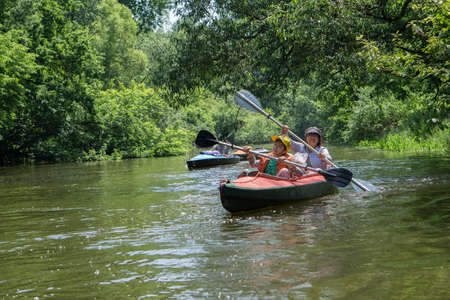 River Goryn. Ukraine. June 10, 2020; A group of tourists swim on the river in multi-colored kayaks.のeditorial素材