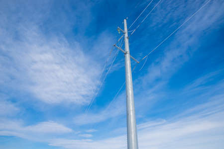 High voltage power line pillar against a blue winter sky. Frost on the surface.の写真素材