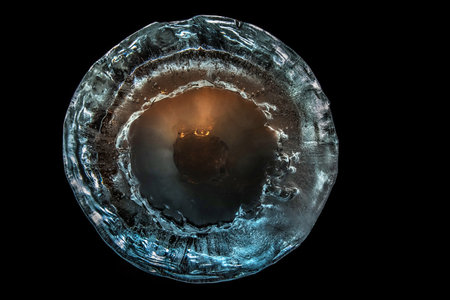 The texture of ice with frozen bubbles, backlit by artificial light.の写真素材