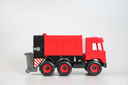 Plastic car. Toy model isolated on a white background. Red truck for the transport of garbage.の写真素材