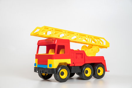 Children's toy plastic car isolated on white background. Red fire truck.