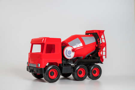 Multi-colored plastic children's toy cars on a white background. Red concrete truck.