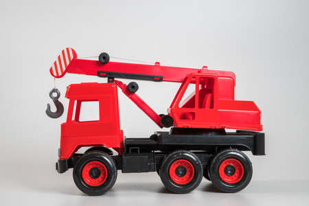 Multi-colored plastic children's toy cars on a white background. Red truck crane.の写真素材