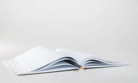 Expanded checkered notebook with open sheets and pencil. Selective focus. Blurred background.の写真素材