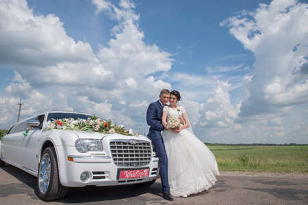 Lutsk. Ukraine. July 2, 2017; The bride and groom near the wedding limousine.のeditorial素材