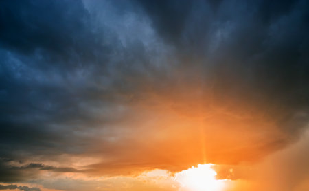 Sunset with rain and dark clouds. Sunshine, sun, rays.の写真素材