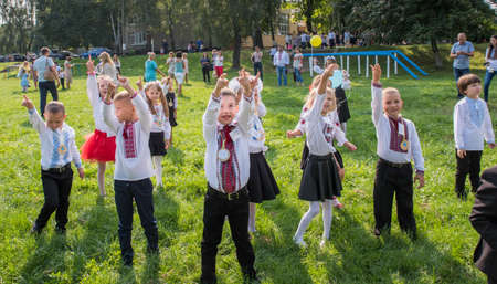 Lutsk. Ukraine. September 1, 2018; Children go to school in the first class. Holiday knowledge. Launch yellow and blue balloons into the sky.のeditorial素材