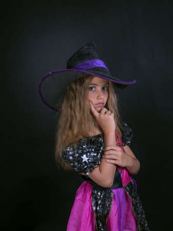 A girl dressed as a witch and a wide-brimmed hat for Halloween.の写真素材