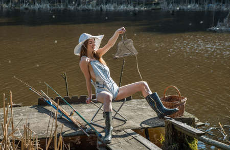 Girl with fish caught in the lakeの写真素材