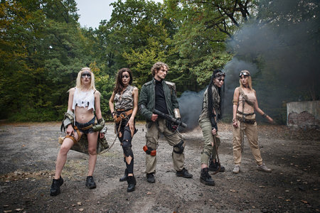 A group of young people in tattered clothes after the apocalypse. Smoke, grunge, chains, aggressive...