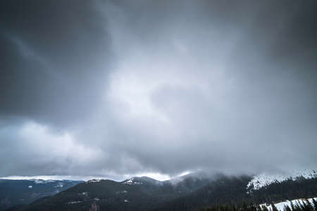 Winter mountains with snow under a dark winter sky.の写真素材