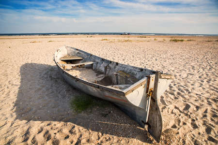 Old rusty boats on the beach sand of the morning seaの写真素材