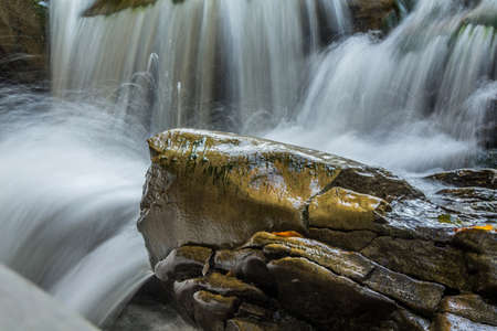 The fast flow of a mountain river among the stones. long exposure. motion blur. selective focus.の写真素材