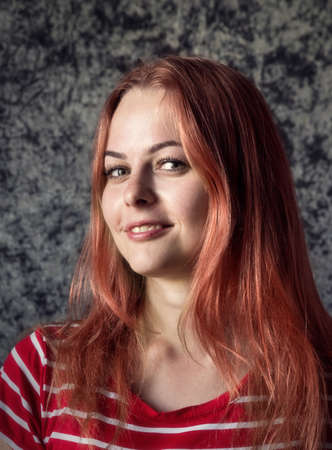 The girl the blonde in a red striped dress with glasses on a dark background.の写真素材