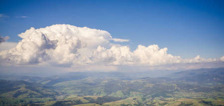 Cumulus clouds over summer mountain valleys.の写真素材