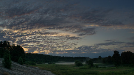 Foggy dawn over the floodplain. Clouds illuminated by the morning sun.の写真素材