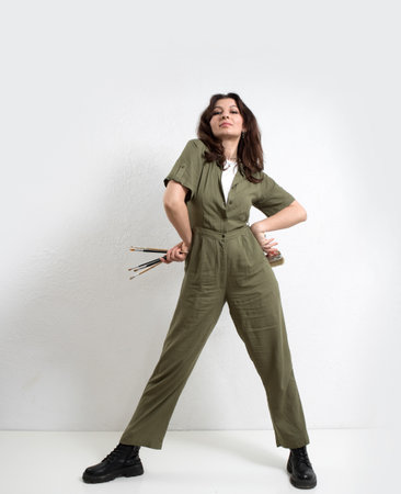 Woman artist in overalls with brushes for painting on a white background.の写真素材
