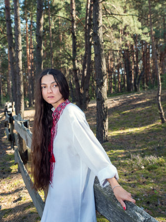 Long-haired Ukrainian girl in an embroidered national shirt in the forestの写真素材