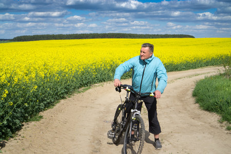 Cyclist in a rapeseed field.の写真素材