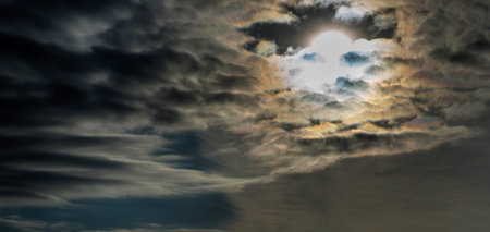 The sun, partially hidden by dark clouds.の写真素材
