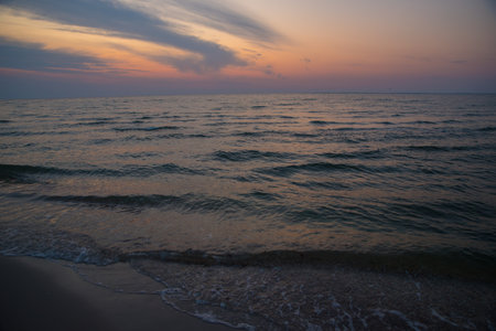 Evening over the sea. Waves with light reflections from the sky.の写真素材