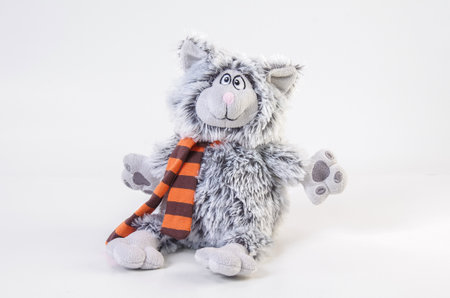 Children's soft toy. Plush shaggy cat with a scarf on a white background.の写真素材