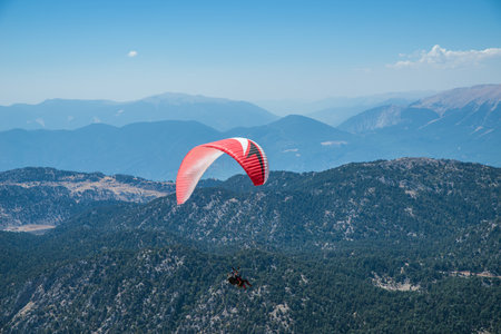 Multi-colored paraglider over the mountains in the haze.の写真素材