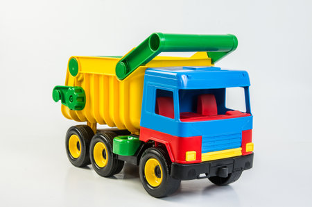 Multi-colored plastic toy trucks for children's games on a white background. Dumper.の写真素材