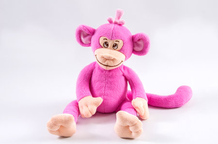 Plush children's toy pink monkey on a white background.の写真素材