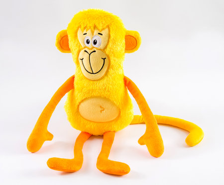 Plush children's toy yellow monkey on a white background.の写真素材