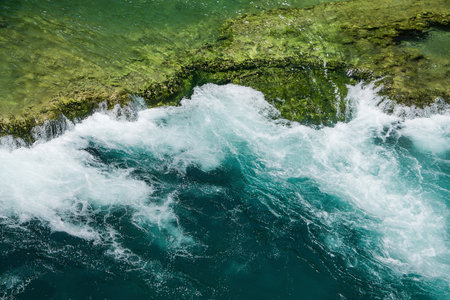 Waterfall among the green summer forest.