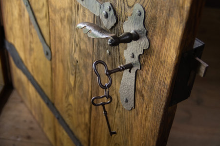 Keys in the keyhole of old wooden doors.の写真素材