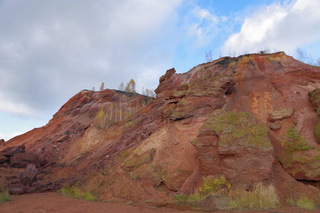 Colorful Red Cliffs and Eroded Hills Under Dramatic Sky
