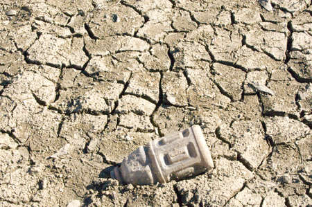 Dry cracked lake bed with trashの写真素材