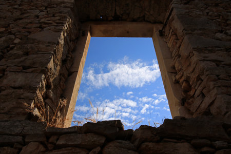 View of the sky through the window of an old stone house, Humac, ghost village, abandoned village on Hvar island, Croatiaの写真素材
