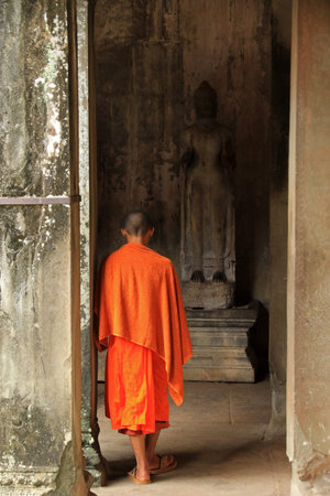 Unidentified buddhist monk walking in front of the temple Angkor Wat, Cambodiaの写真素材