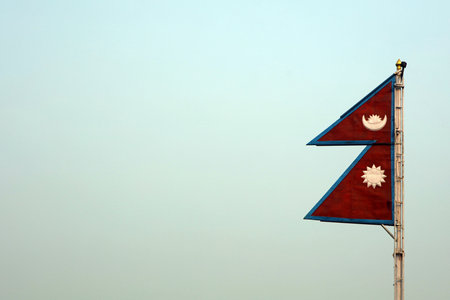Flag of Nepal waving in the wind on blue sky background with copy spaceの写真素材