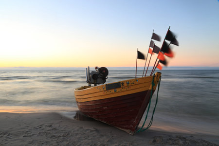 Fishing boat on the beach at sunset, fishing boat on the beach. Traditional wooden fishing boats on the beach in Debki, Baltic sea, Polandの写真素材
